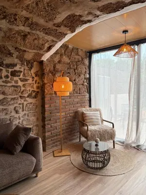a living room with a couch and a chair and a table at Suíte Sant Sebastià con jacuzzi, sauna y jardín in Moià