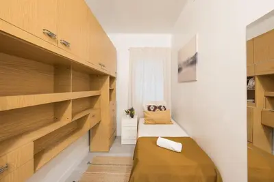 a small bedroom with wooden shelves and a bed at Llorens Sagrada Familia in Barcelona