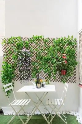 a table and two chairs and a fence with plants at Llorens Sagrada Familia in Barcelona