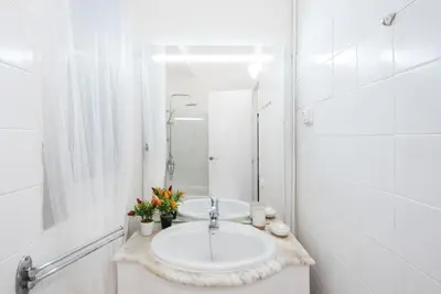 a white bathroom with a sink and a mirror at Llorens Sagrada Familia in Barcelona