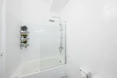 a white bathroom with a shower and a sink at Llorens Sagrada Familia in Barcelona