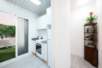 a kitchen with white walls and a sliding glass door at Llorens Sagrada Familia in Barcelona