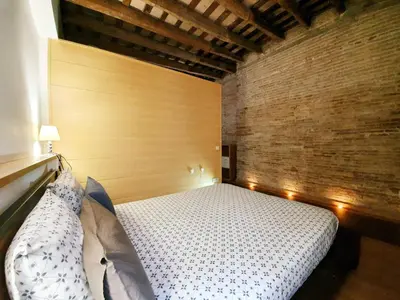 a bedroom with a bed and a wooden wall at Apartamento Llibertat centro in Vilanova i la Geltrú