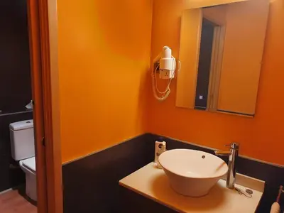 an orange bathroom with a sink and a mirror at Apartamento Llibertat centro in Vilanova i la Geltrú