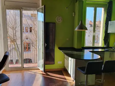 a kitchen with green walls and a table and a window at Apartamento Llibertat centro in Vilanova i la Geltrú