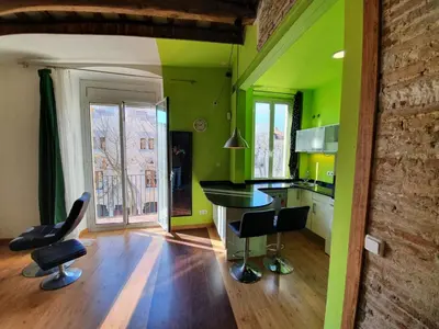 a kitchen with green walls and a table and chairs at Apartamento Llibertat centro in Vilanova i la Geltrú