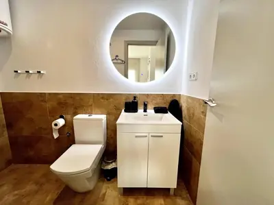 a bathroom with a white toilet and a mirror at Loft moderno en buena ubicación in Terrassa