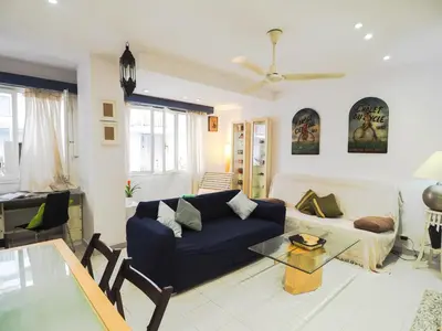 a living room with a blue couch and a table at Sunflower Apartment by Hello Homes Sitges in Sitges