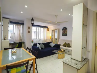 a living room with a blue couch and a table at Sunflower Apartment by Hello Homes Sitges in Sitges