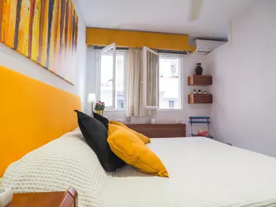 a bedroom with a white bed with yellow walls at Sunflower Apartment by Hello Homes Sitges in Sitges