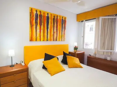 a bedroom with a bed with yellow pillows at Sunflower Apartment by Hello Homes Sitges in Sitges