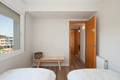 a small bedroom with two beds and a table at Casa Natura Gava Beach in Gavà
