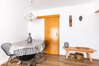 a dining room with a table and chairs and a chandelier at Casa Natura Gava Beach in Gavà