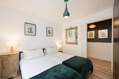 a bedroom with a large white bed and two lamps at Vintage 3 Bdr Apartment in Esplugues de Llobregat