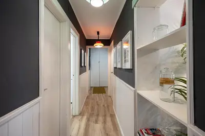 a hallway with white and black walls and wood floors at Vintage 3 Bdr Apartment in Esplugues de Llobregat