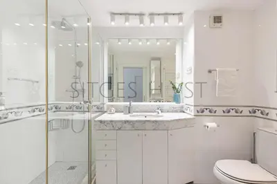 a white bathroom with a sink and a shower at Sitges ARENA - dos piscinas frente al mar in Sitges