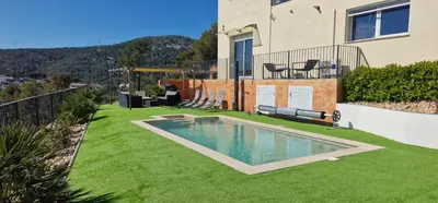 a large grass yard with a trampoline in front of a house at Villa Contenta Canyelles in Canyelles