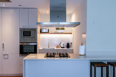 a kitchen with white cabinets and a counter top at Factory Apartments Barcelona in Barcelona