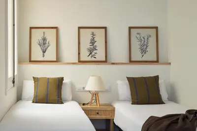 two beds in a room with three pictures on the wall at Factory Apartments Barcelona in Barcelona