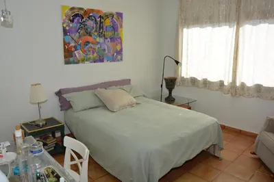 a bedroom with a bed and a painting on the wall at Villa Sitges Julia Vista Espectacular 2 k m s de la Playa Comoda & Area Tranquila Amplitud interior y plana in Sitges