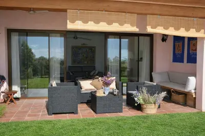 a patio with wicker chairs and a couch and windows at Villa Sitges Julia Vista Espectacular 2 k m s de la Playa Comoda & Area Tranquila Amplitud interior y plana in Sitges