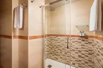 a shower with a glass door in a bathroom at Petit Palace Eixample in Barcelona
