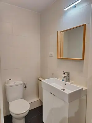 a white bathroom with a toilet and a sink at Cute apartment Sant Adria beach in Sant Adria de Besos