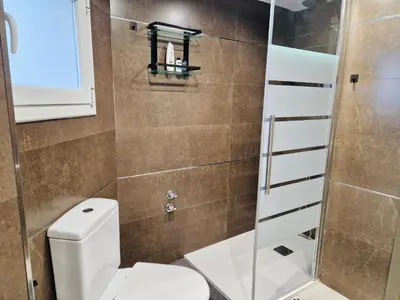 a bathroom with a toilet and a shower at Casa con vistas al mar in Castelldefels