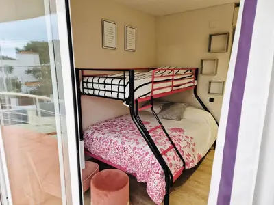 a bunk bed in a room with a balcony at Casa con vistas al mar in Castelldefels