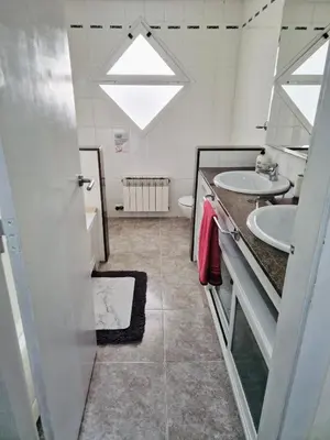 a bathroom with two sinks and a skylight at Casa con vistas al mar in Castelldefels