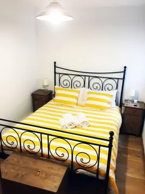 a yellow and white bed with two towels on it at MODERNO APARTAMENTO EN EL CENTRO in Vilanova i la Geltrú