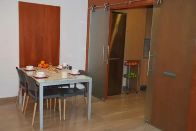 a kitchen with a table with chairs and a refrigerator at Apartaments Independencia in Barcelona