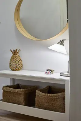 a mirror on a wall above a shelf with baskets at BBarcelona Calabria Flat in Barcelona