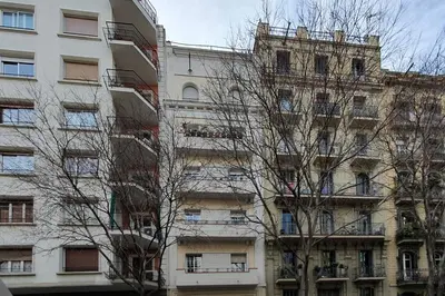 a tall building with trees in front of it at BBarcelona Calabria Flat in Barcelona