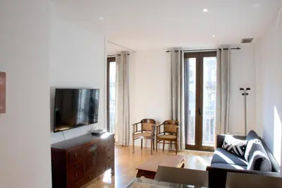 a living room with a couch and a tv at SWEET BCN Rambla 48 in Barcelona