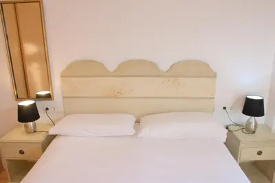 a bedroom with a white bed with two lamps at SWEET BCN Rambla 48 in Barcelona