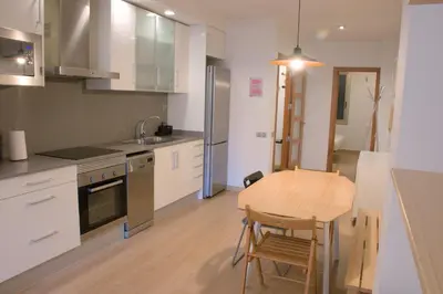 a kitchen with a wooden table and a table and chairs at SWEET BCN Plaza Universidad in Barcelona