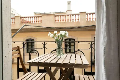 a vase of flowers sitting on a table on a balcony at Lodging Apartments Barceloneta Mar in Barcelona