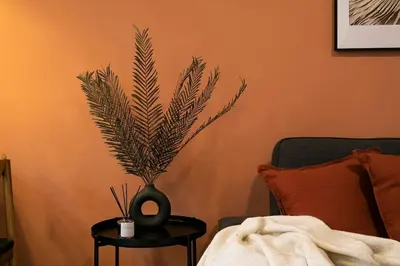a vase with a plant on a table next to a bed at Lodging Apartments Barceloneta Mar in Barcelona