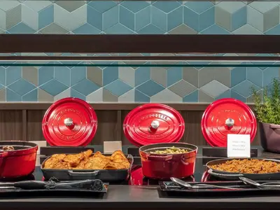 a buffet of food in red dishes on a table at Hilton Diagonal Mar Barcelona in Barcelona