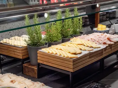 a buffet line with various types of bread and cheese at Hilton Diagonal Mar Barcelona in Barcelona
