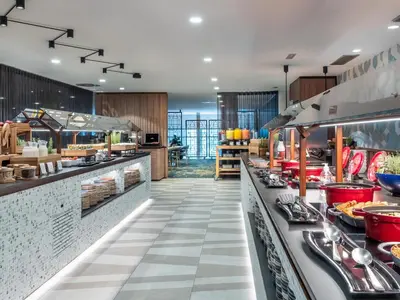 a restaurant with a buffet line with food at Hilton Diagonal Mar Barcelona in Barcelona