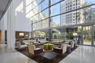 a courtyard with tables and chairs in a building at Hilton Barcelona in Barcelona