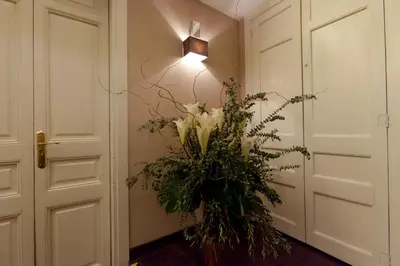 a vase of flowers in a hallway with a light at Casa Boutique Barcelona in Barcelona