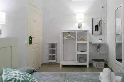 a white bedroom with a bed and a sink at Blanc Guest House in Barcelona