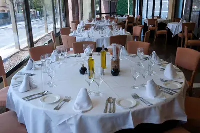 a table with white plates and wine glasses on it at Ciudad de Castelldefels in Castelldefels