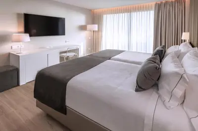 a hotel room with a large bed and a desk at Hotel Playafels in Castelldefels