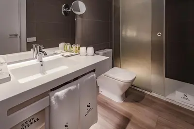 a bathroom with a sink and a toilet and a mirror at Hotel Playafels in Castelldefels