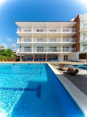 a swimming pool in front of a building at Apartamentos Sunway Amapola in Sitges
