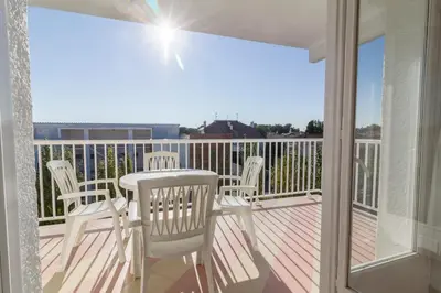 a balcony with chairs and a table on a deck at Apartamentos Sunway Amapola in Sitges